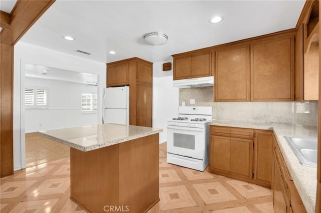 kitchen with tasteful backsplash, sink, light parquet flooring, and white appliances