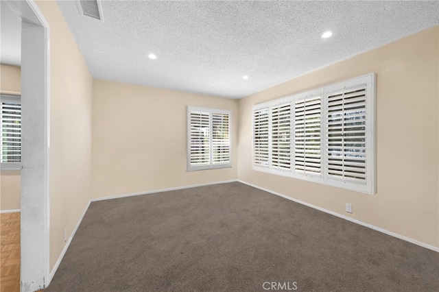 unfurnished room featuring carpet and a textured ceiling