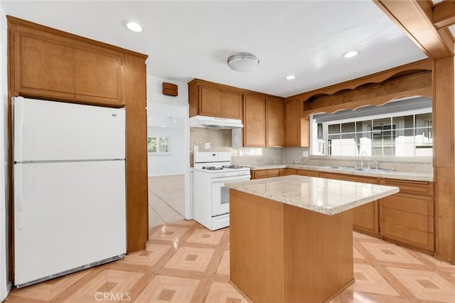 kitchen with a center island, white appliances, light parquet floors, sink, and decorative backsplash