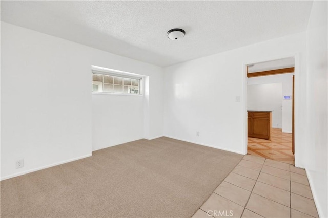 carpeted empty room featuring a textured ceiling