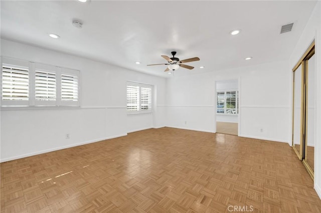 spare room with ceiling fan and light parquet flooring