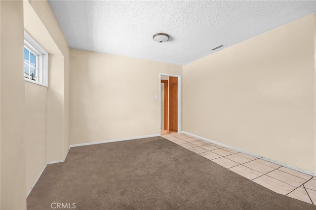 unfurnished room with light carpet and a textured ceiling