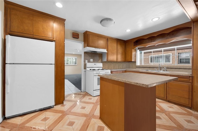 kitchen featuring white appliances, backsplash, light parquet floors, sink, and a kitchen island