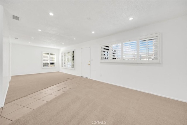 carpeted empty room with a textured ceiling