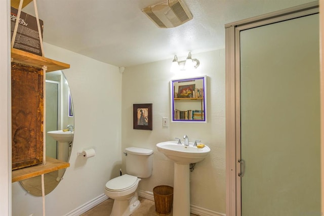 bathroom featuring tile patterned flooring, toilet, a shower with door, and sink