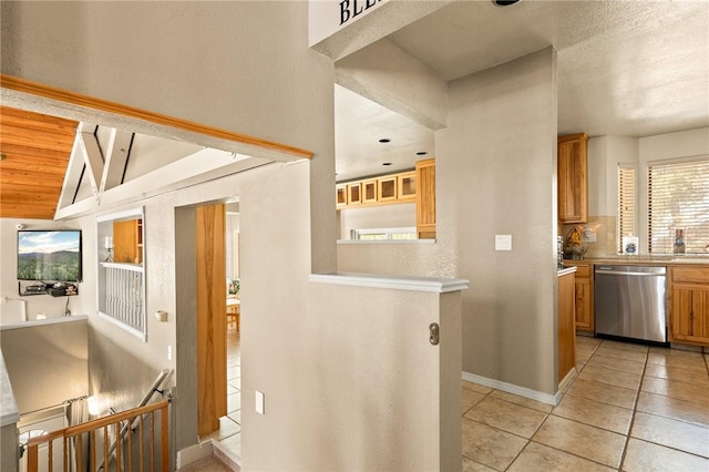 interior space with vaulted ceiling, dishwasher, backsplash, light tile patterned floors, and wooden ceiling