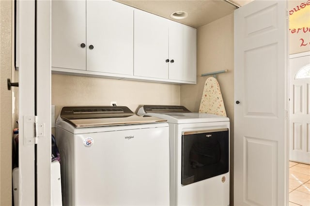 laundry area with cabinets, light tile patterned floors, and independent washer and dryer