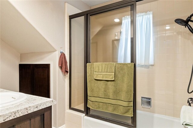 bathroom with vanity and shower / bath combination with glass door