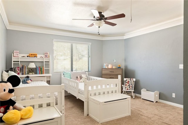 bedroom with ornamental molding, a nursery area, light carpet, and ceiling fan