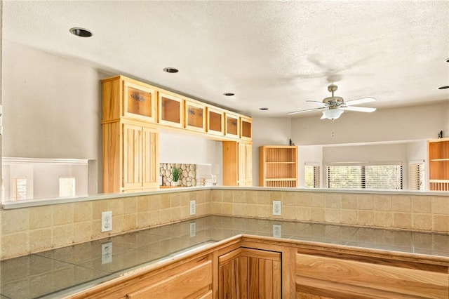 kitchen with backsplash, a textured ceiling, and ceiling fan