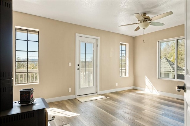 entryway featuring ceiling fan, a textured ceiling, and light wood-type flooring