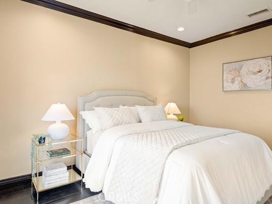 bedroom with ceiling fan, wood-type flooring, and ornamental molding