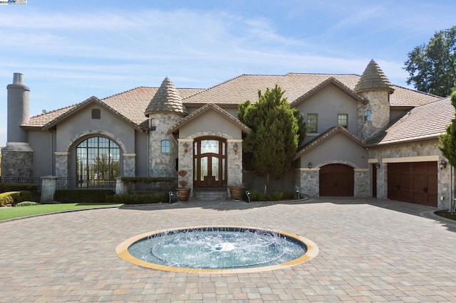 french country inspired facade featuring an in ground hot tub, french doors, and a garage