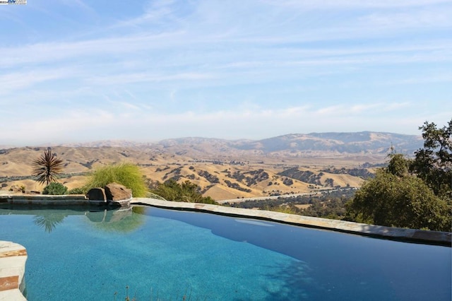 view of pool with a water and mountain view