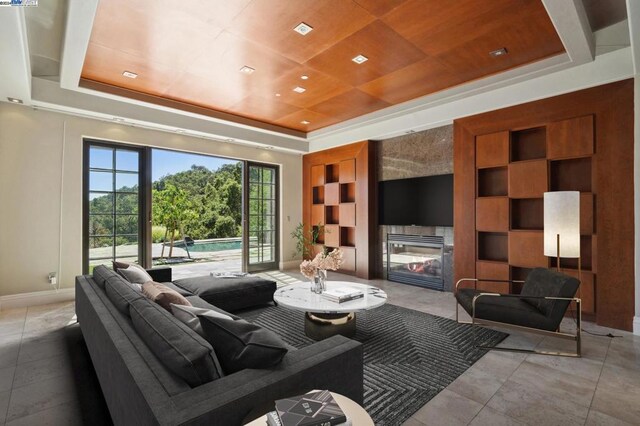 home theater room featuring a raised ceiling and a fireplace