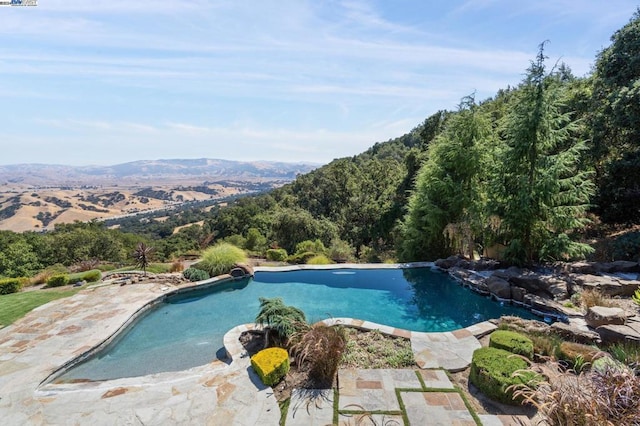 view of pool featuring a mountain view and a patio area