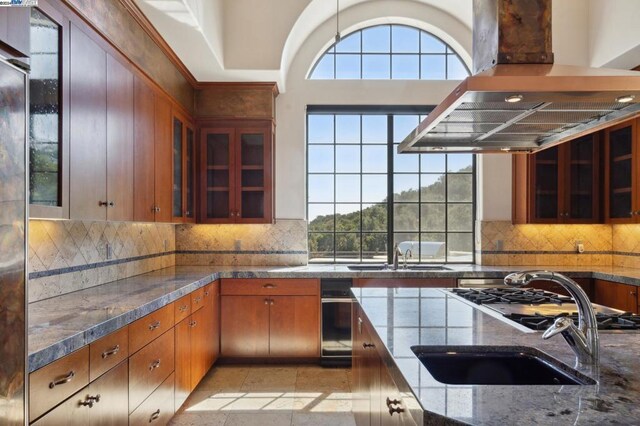 kitchen with tasteful backsplash, island exhaust hood, and sink