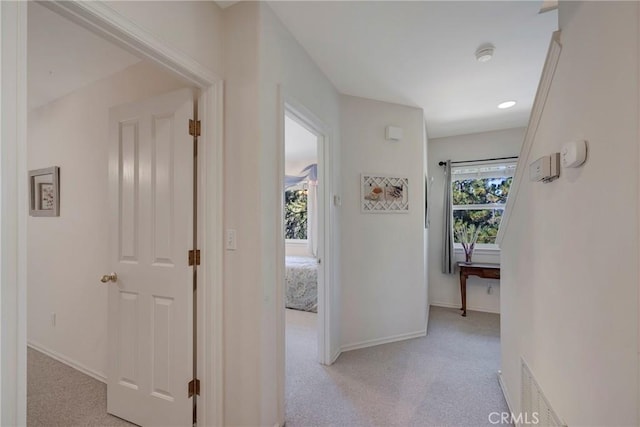 hall with light colored carpet