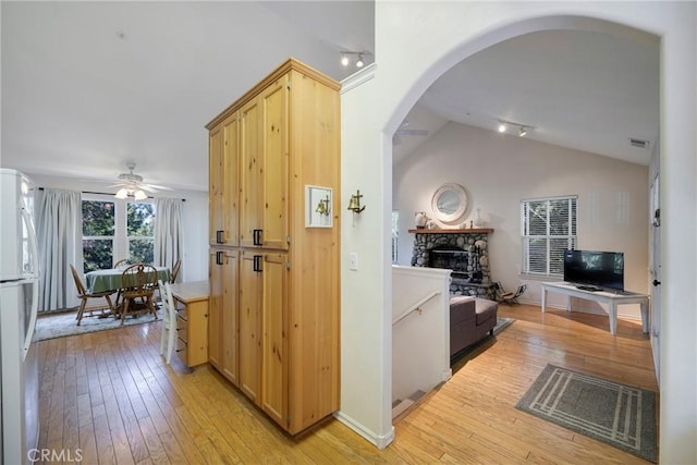 kitchen with light brown cabinets, white fridge, ceiling fan, and light hardwood / wood-style floors