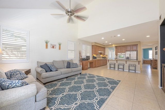 tiled living room featuring ceiling fan and high vaulted ceiling