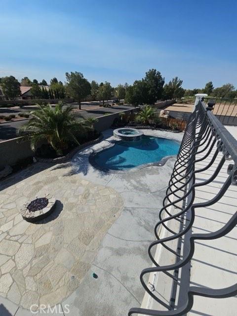 view of pool with a pool with connected hot tub