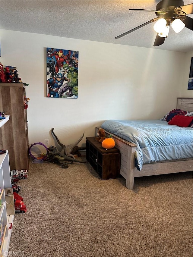 carpeted bedroom featuring ceiling fan and a textured ceiling