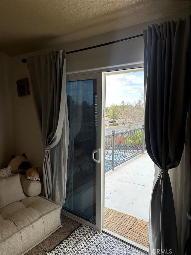 doorway to outside with a textured ceiling