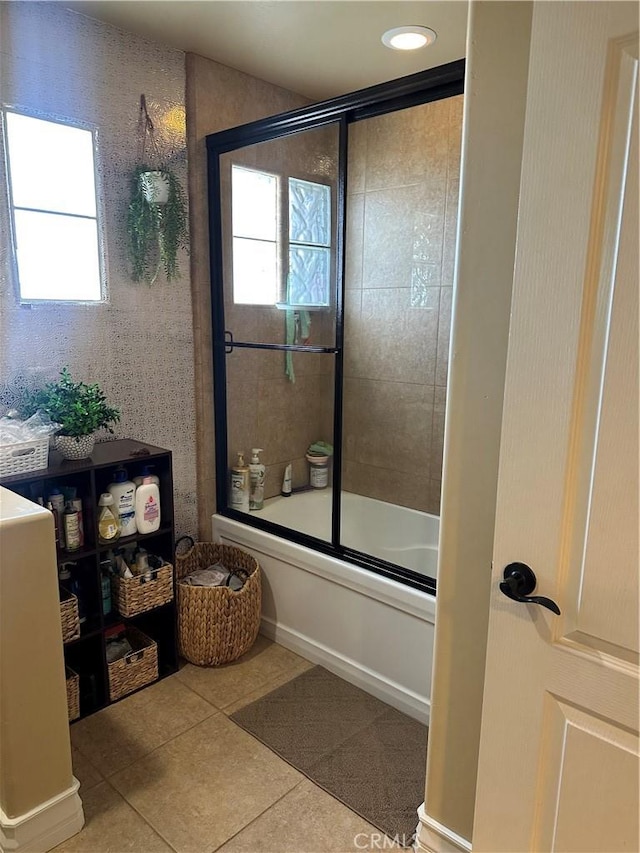 full bathroom featuring tile patterned flooring and bath / shower combo with glass door