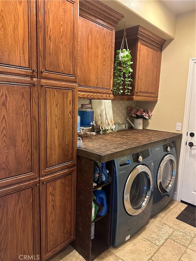 washroom featuring washer and clothes dryer and cabinet space