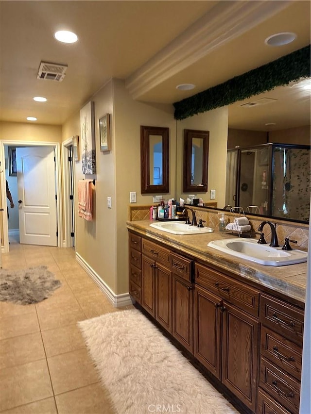 bathroom featuring tile patterned flooring, visible vents, a sink, and a shower stall