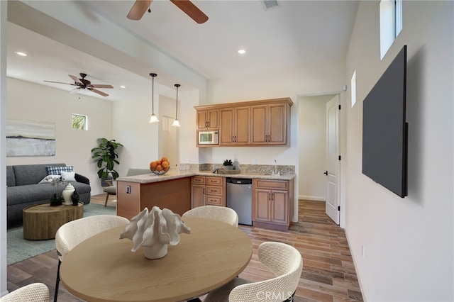 kitchen with hardwood / wood-style floors, ceiling fan, decorative light fixtures, kitchen peninsula, and stainless steel appliances