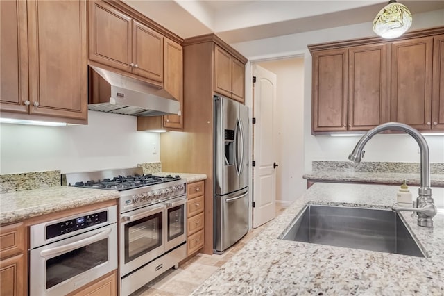 kitchen featuring light stone countertops, sink, and appliances with stainless steel finishes