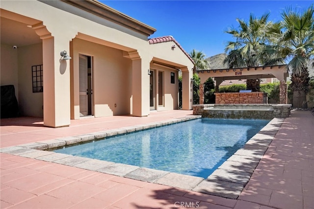 view of pool with a patio area and an in ground hot tub