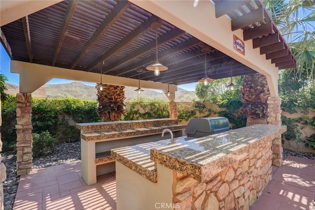 view of patio with a mountain view, a grill, exterior kitchen, and a pergola