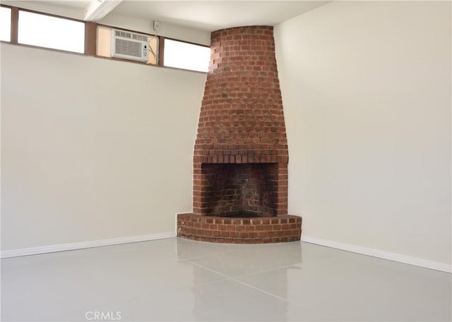 unfurnished living room with a wall mounted air conditioner, tile patterned floors, and a brick fireplace