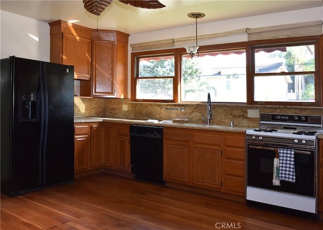 kitchen featuring decorative light fixtures, dark hardwood / wood-style floors, a wealth of natural light, and black appliances