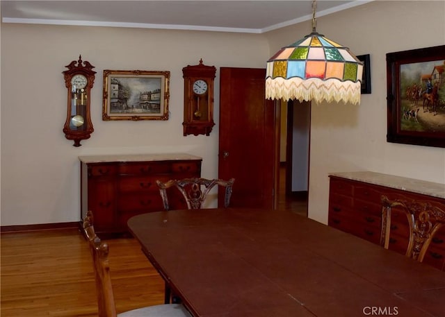 dining room featuring light wood-type flooring and crown molding