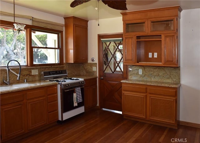 kitchen featuring dark hardwood / wood-style flooring, backsplash, ceiling fan, sink, and white range with gas stovetop