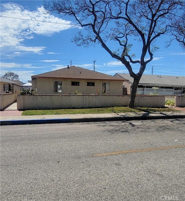 view of front of house featuring a fenced front yard and stucco siding