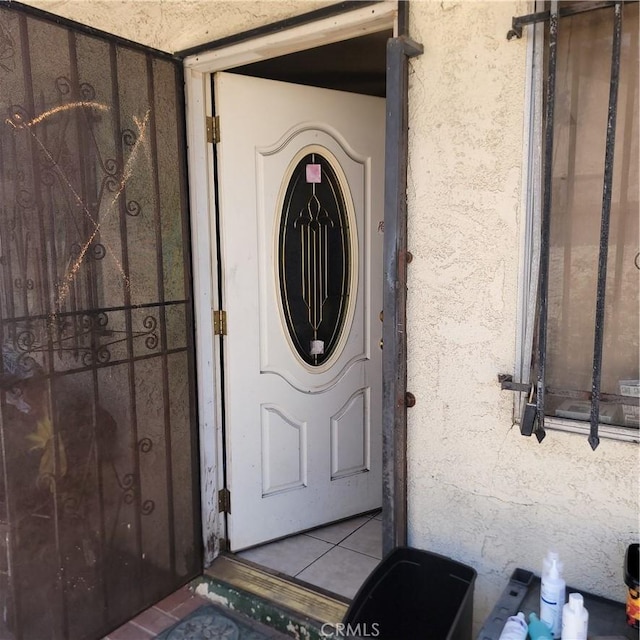 doorway to property featuring stucco siding