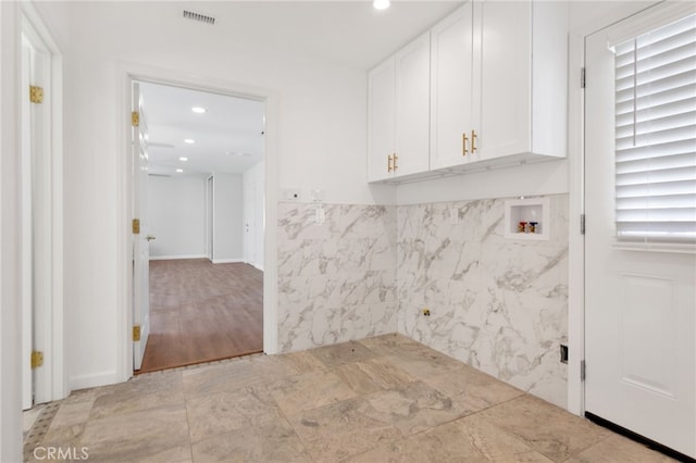 laundry area featuring cabinets, light hardwood / wood-style floors, and washer hookup