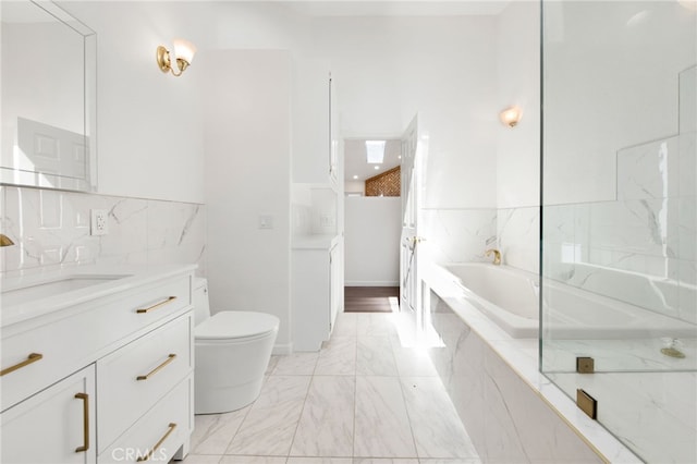 bathroom featuring tiled tub, vanity, and toilet