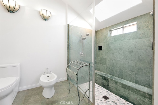 bathroom with a bidet, tile patterned flooring, toilet, and tiled shower