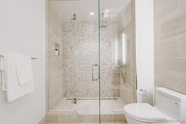 bathroom featuring toilet and an enclosed shower