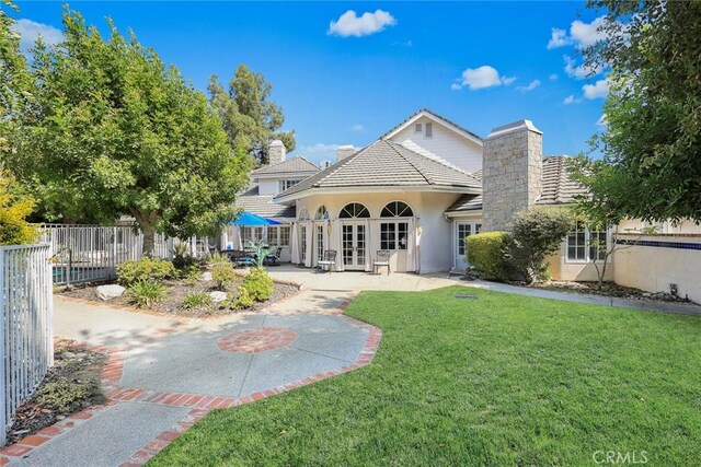 rear view of property with a yard and french doors