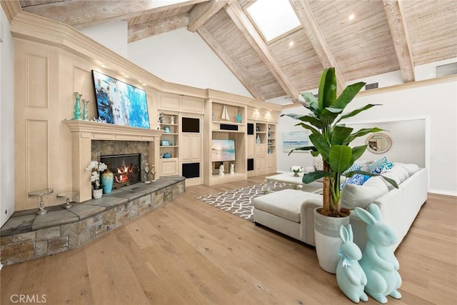 living room with a fireplace, beam ceiling, a skylight, and hardwood / wood-style flooring