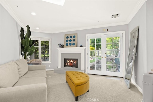 living room featuring a wealth of natural light, light colored carpet, and ornamental molding