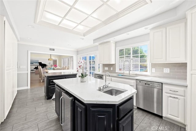 kitchen featuring sink, stainless steel dishwasher, a kitchen island, white cabinetry, and beverage cooler