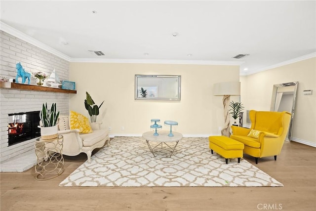 sitting room with crown molding, light wood-type flooring, and a fireplace