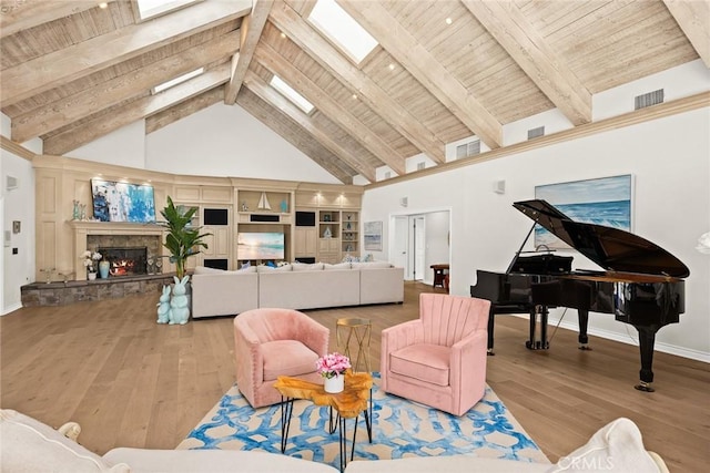 living room featuring high vaulted ceiling, a skylight, beamed ceiling, light hardwood / wood-style floors, and wood ceiling